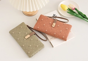 Detail of long women's quilted wallet with tulip print and golden metal twist lock