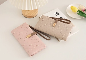 Close-up of pink and beige quilted wallets with tulip floral patterns and metal clasps