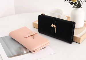 Detail of long PU leather wallets with puzzle-shaped metal clasps and zipper closure