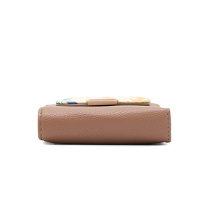 Detail view of the floral patterned base on a brown litchi grain leather wallet