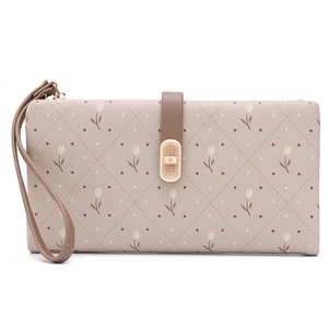 Detail of tulip pattern on beige leather wallet with gold twist lock and wrist strap