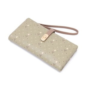 Detail of green quilted wallet with tulip print, gold twist lock and wrist strap