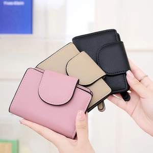 Detailed close-up of compact PU leather wallets in pink, beige, and black pebble texture