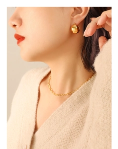 Close-up of a 18K gold plated bead earring and fine chain necklace on a model
