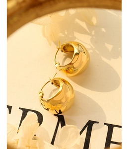 Detailed view of chunky 18K gold plated C-shaped hoop earrings with a mirror finish