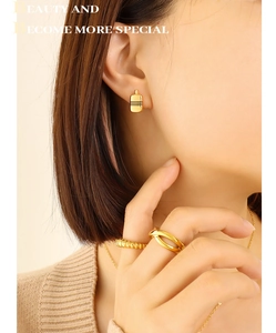 Détail de la parure bijoux dorée géométrique avec boucles d'oreilles et bagues