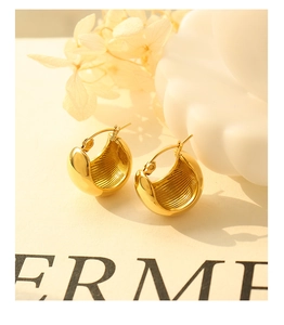 Detailed view of C-shaped 18K gold plated earrings with inner vertical striped texture