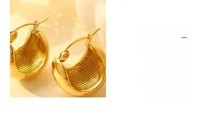 Detail of 18K gold plated C-shaped earrings showing textured inner wall and mirror finish