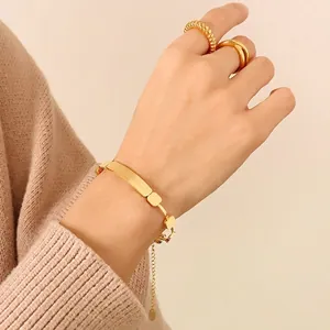 Polished 18K gold-plated stainless steel engraved plaque bracelet with minimalist rings
