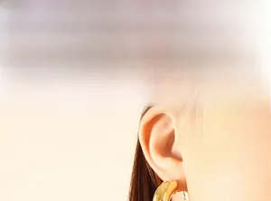 Close-up of chunky gold hoop earrings with a polished finish worn by a model