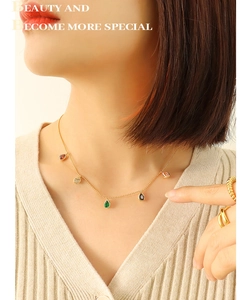 Detail of 18K gold plated necklace with five colorful teardrop pendants on female model