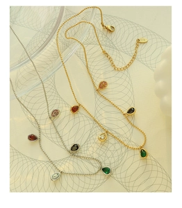 Close-up of teardrop zircon pendants on bead chains featuring the K18 engraving