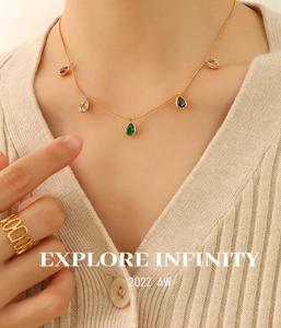 Detail of gold necklace featuring five colorful teardrop-shaped zircon pendants on model