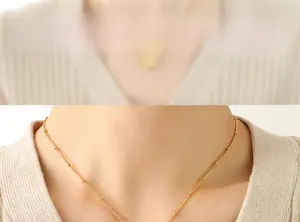Close-up of a 18k gold-plated beaded chain necklace with delicate minimalist ball details