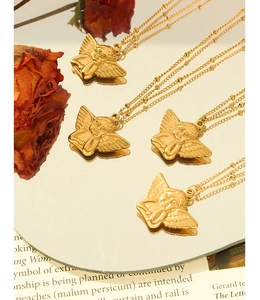 Detailed close-up of golden Cupid angel pendant with wings on a mirror with roses