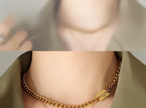 Detail of layered gold cuban chain necklace with engraved rectangular pendant on model