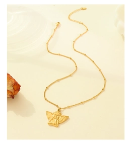Detailed close-up of 18k gold angel pendant on a beaded chain with vintage hip hop style