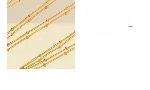 Detail of 18k gold beaded satellite chain necklace with polished metallic finish