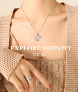Silver angel pendant necklace and textured ring styled with beige knitwear attire