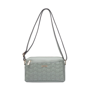 Détail d'un sac bandoulière vert menthe avec motif matelassé vague et logo métallique