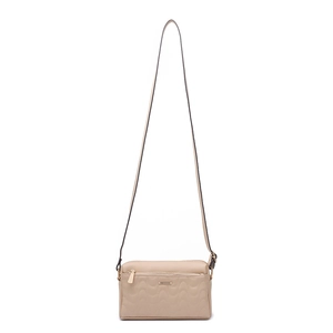 Détail du sac bandoulière beige matelassé avec surpiqûres et double fermeture éclair