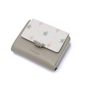 Close-up of leafy printed pattern and leather texture on a folding PU wallet