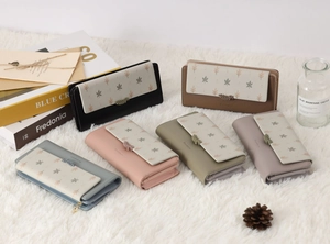 Vue détaillée de portefeuilles longs en cuir PU en plusieurs couleurs sur fond peluche