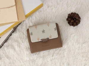 Detail view of a compact PU leather wallet featuring leaf prints and a decorative leaf buckle