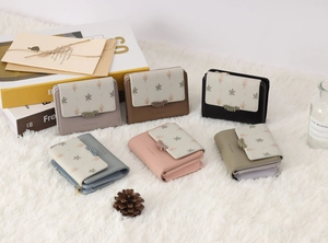 Close-up of small PU leather wallets featuring elegant leaf prints and decorative clasps