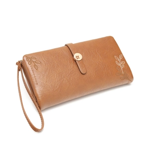Detail of brown PU leather wallet featuring leaf embossing and a floral gold snap button