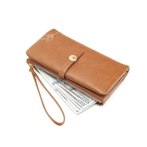 Brown long leather wallet with leaf embroidery and wrist strap on white background
