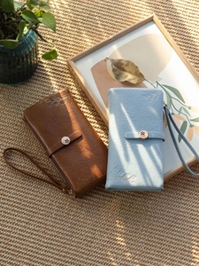 Detailed view of long PU leather wallets with leaf embroidery and metal floral buttons
