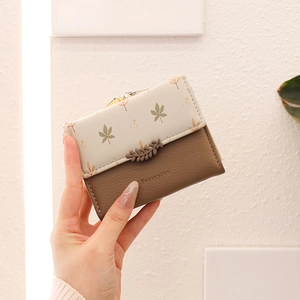 Close-up of leather wallet with leaf patterns and vintage metal buckle clasp
