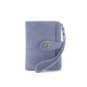 Macro shot of light blue mini wristlet wallet with PZ logo and soft leather texture
