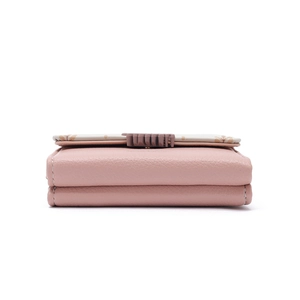 Detail of pink and beige leather wallet showing neat stitching and layered structure