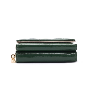Detail view of dark green quilted faux leather wallet with gold zipper and stitching