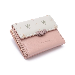 Detail of pink trifold wallet featuring leaf buckle and lychee leather texture