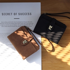 Detail of vintage matte leather wristlet wallets in black and brown with metal PZ logo
