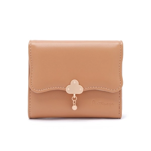 Close-up of light brown wallet with scalloped edge and golden cloud pendant detail