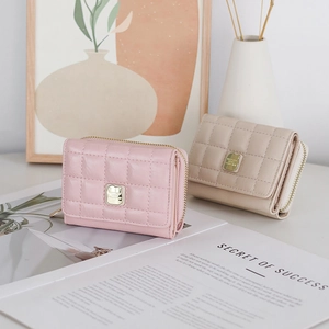 Short quilted PU leather wallets in pink and beige with gold logo on a lifestyle background