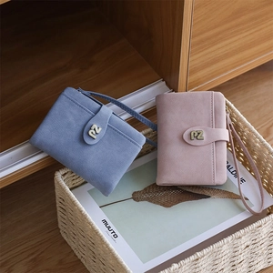 Close-up of minimalist matte leather short wallets in blue and pink with metal PZ logo