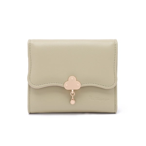Detail of sage green trifold wallet with cloud-shaped metal buckle and petal pendant