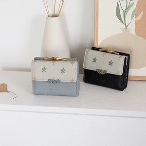 Detail of leaf buckle closure on short tri-fold wallets in grey-blue and black faux leather