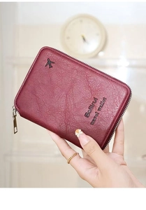 Detail of burgundy lychee leather travel wallet with zipper and airplane logo