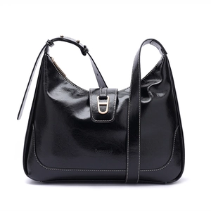 Détail du sac sous le bras en cuir noir brillant avec bandoulière réglable et boucle