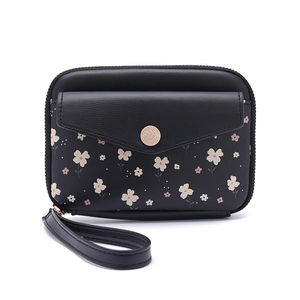 Détail du portefeuille floral en cuir avec double zip et logo sur la poche avant