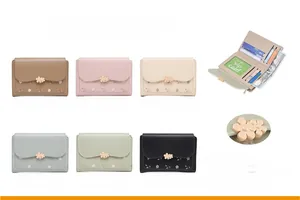Detailed view of floral embroidered wallet with multiple card slots and metal flower clasp