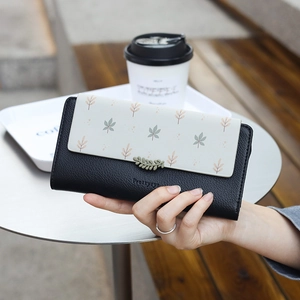 Gros plan du portefeuille en cuir PU à fleurs avec pendentif feuille et grain lychee