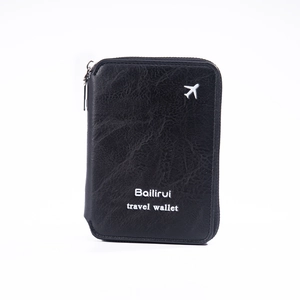 Detail of black travel wallet showing pebble leather texture and silver airplane logo