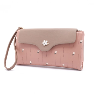 Close-up of pink and taupe bicolor women's wallet with floral clasp and wrist strap